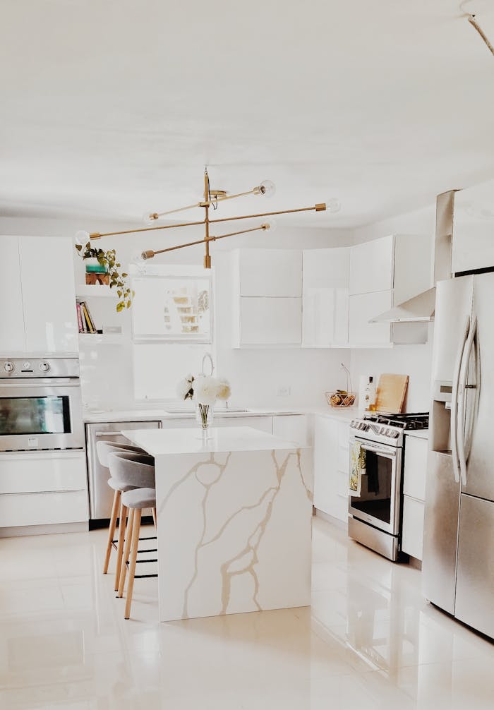 gallery-3 A bright, modern kitchen featuring white cabinetry, stainless steel appliances, and minimalist decor.